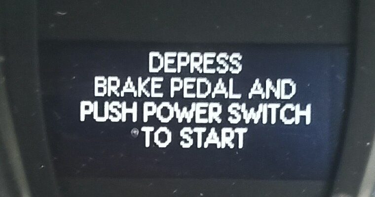 Надпись DEPRESS BRAKE PEDAL AND PUSH POWER SWITCH TO START на дисплее Lexus
