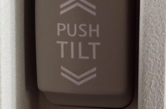 Кнопка PUSH TILT между надписями OPEN и CLOSE на потолке автомобиля