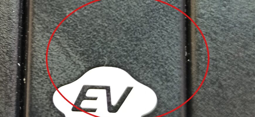 Кнопка с надписью EV в овальной рамке на панели автомобиля