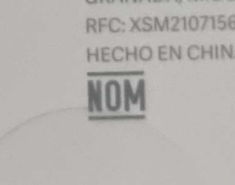 Знак NOM на коробке — снято на упаковке машинки для стрижки Xiaomi